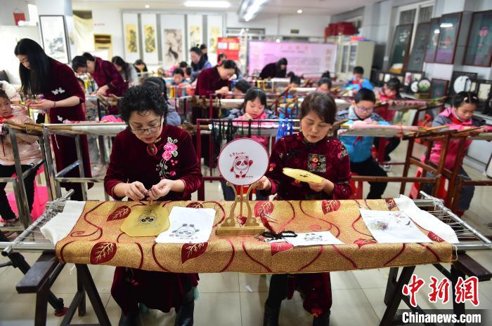 江西省級(jí)非遺豫章繡傳承人手把手指導(dǎo)小學(xué)生繡制2022年北京冬奧會(huì)吉祥物“冰墩墩”形象?！∮髟屏?攝