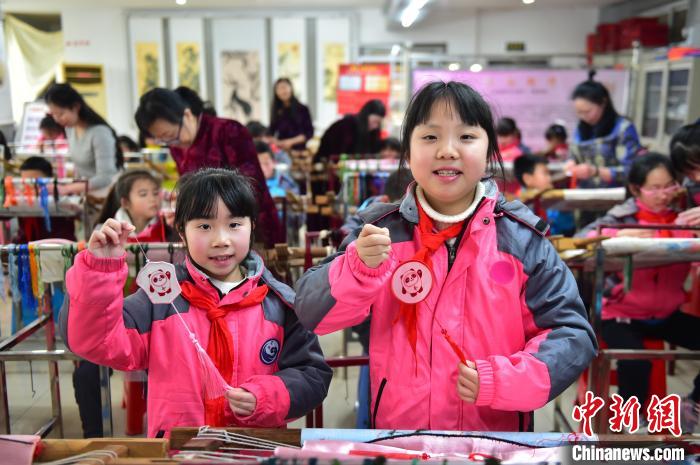 圖為小學(xué)生展示繡制好的2022年北京冬奧會(huì)吉祥物“冰墩墩”形象?！∮髟屏?攝