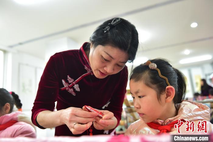 江西省級(jí)非遺豫章繡傳承人手把手指導(dǎo)小學(xué)生繡制2022年北京冬奧會(huì)吉祥物“冰墩墩”形象?！∮髟屏?攝