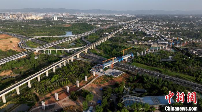 航拍正在建設(shè)的跨越成都繞城高速公路連續(xù)梁施工現(xiàn)場(chǎng)，旁邊依次為已運(yùn)營(yíng)的成渝高速鐵路和機(jī)場(chǎng)高速公路?！⒅铱?攝