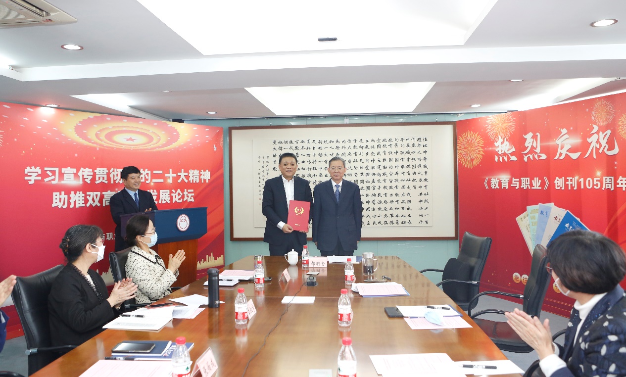 郝明金為《教育與職業(yè)》雜志編委代表陳曉明頒發(fā)聘書。中華職教社供圖