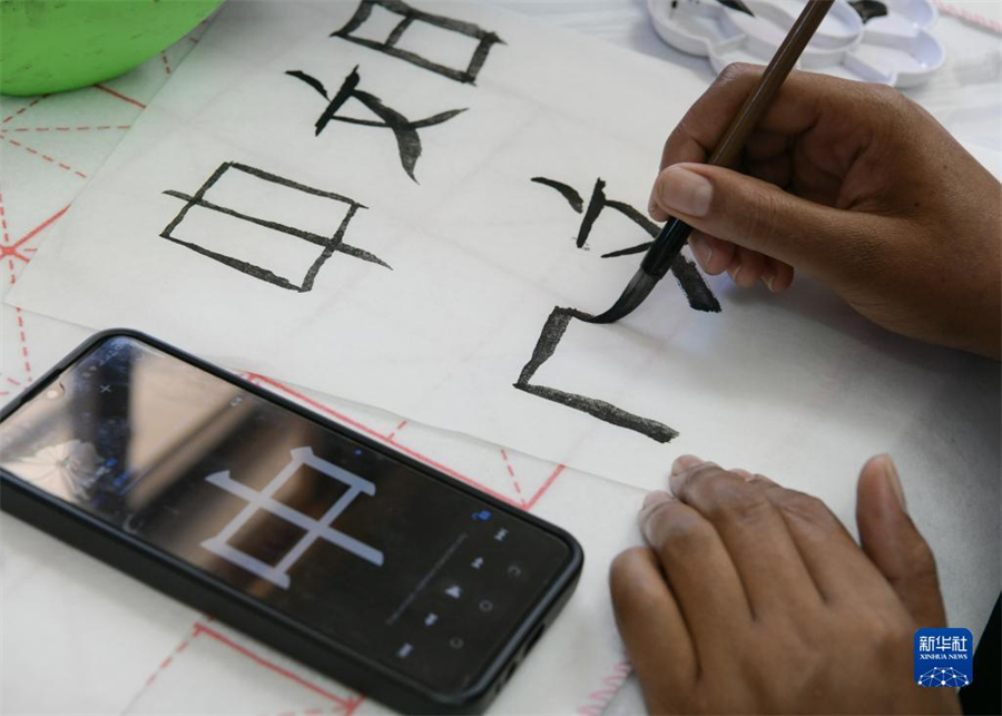 4月18日，肯尼亞學(xué)生在內(nèi)羅畢大學(xué)孔子學(xué)院舉辦的活動上寫毛筆字。肯尼亞內(nèi)羅畢大學(xué)孔子學(xué)院18日舉辦“中文，增進(jìn)文明對話”主題活動，慶祝即將到來的第14個聯(lián)合國中文日?？夏醽唽W(xué)生參與互動，進(jìn)行書法、剪紙、唱中文歌等活動。新華社記者 韓旭 攝