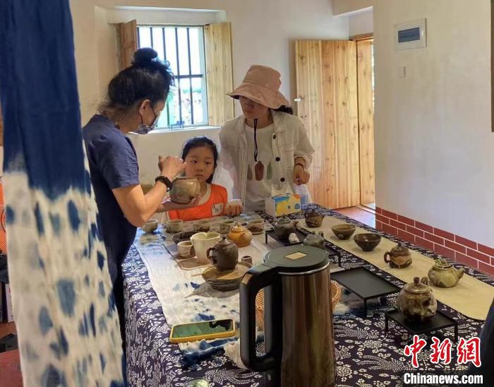 圖為：游客正在咨詢臺(tái)灣柴燒作品。　葉秋云 攝
