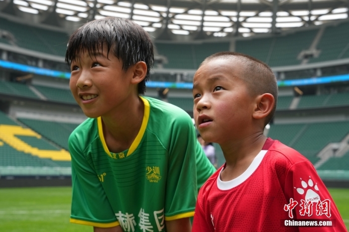 圖為北京國安小球員陳小北和7歲的俄金仁增在一起觀看場內(nèi)播放的紀錄片。<a target='_blank' href='/' _fcksavedurl='/'><p  align=