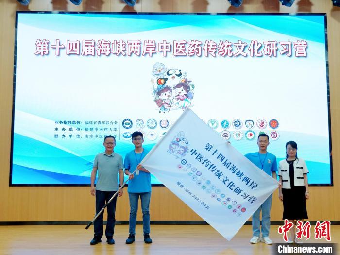 共青團(tuán)福建省委副書記吳雪(右一)、福建中醫(yī)藥大學(xué)黨委副書記林羽(左一)為兩岸學(xué)生代表頒授營旗?！≡S燁婷 攝