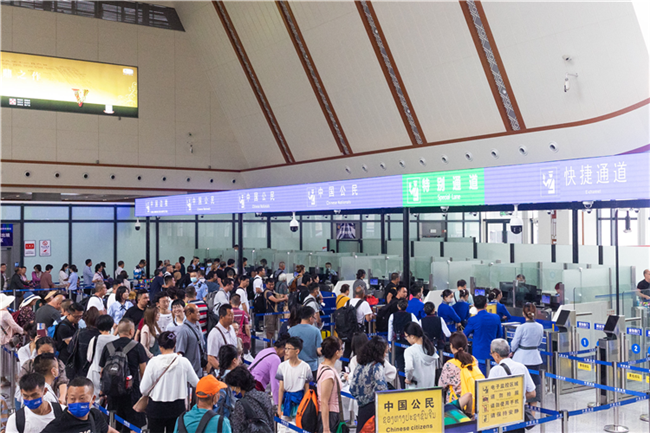 7月22日，乘坐中老鐵路國際旅客列車的旅客在磨憨邊檢大廳排隊候檢。衛(wèi)海林 攝