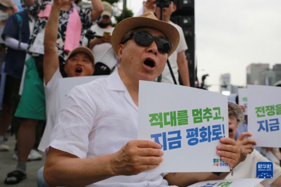 7月22日，在韓國(guó)首爾，人們手舉標(biāo)語(yǔ)參與反戰(zhàn)游行。新華社發(fā)（楊暢 攝）