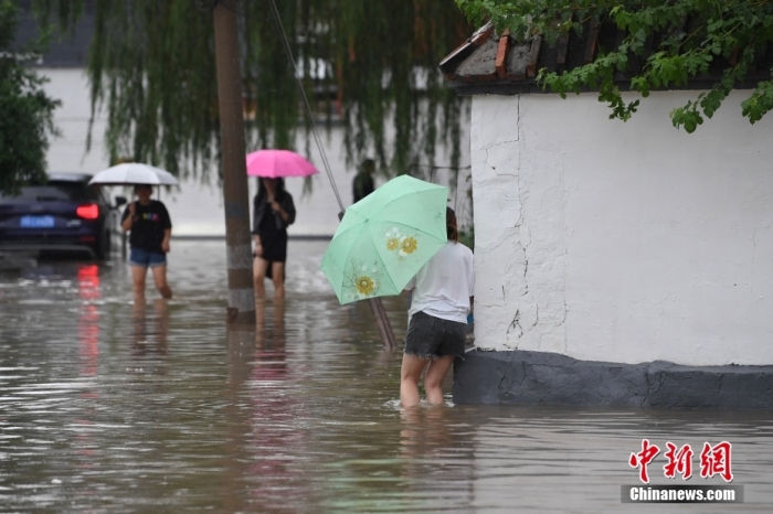7月31日，市民行走在雨中的北京房山區(qū)瓦窯頭村。北京市氣象臺當日10時發(fā)布分區(qū)域暴雨紅色預警信號。北京市水文總站發(fā)布洪水紅色預警，預計當日12時至14時，房山區(qū)大石河流域?qū)⒊霈F(xiàn)紅色預警標準洪水。<a target='_blank' href='/'><p  align=