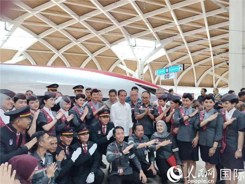 印尼總統(tǒng)佐科與雅萬高鐵乘務(wù)員及中印尼嘉賓合影。人民網(wǎng)記者 李培松攝
