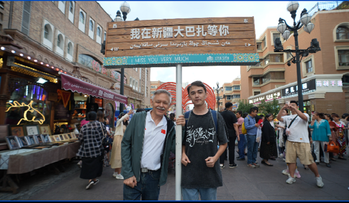 潘維廉和維吾爾族青年伊木蘭“打卡”大巴扎。主辦方供圖