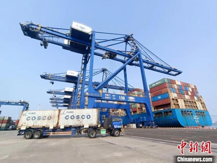 圖為海南洋浦國際集裝箱碼頭，卡車將集裝箱從后方堆場運往碼頭裝卸區(qū)?！堅潞?攝