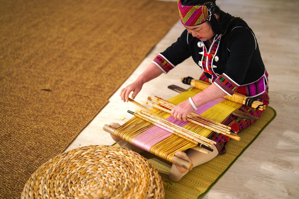 4月17日，黎族傳統(tǒng)紡染織繡技藝國家級代表性傳承人劉香蘭在2023年意大利米蘭設(shè)計周上展示黎錦織造技藝。新華社發(fā)