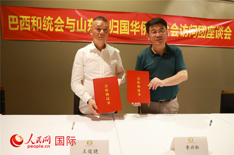 中國僑聯(lián)副主席、山東省僑聯(lián)主席李興鈺（右）與巴西和統(tǒng)會會長王俊曉簽署合作協(xié)議書。人民網(wǎng)記者 陳海琪攝