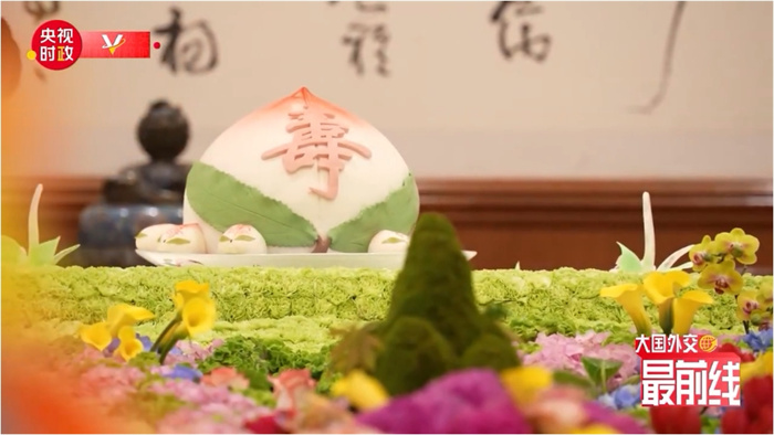 圖為今年7月基辛格訪華時(shí)午宴上的壽桃。來(lái)源：央視新聞截圖