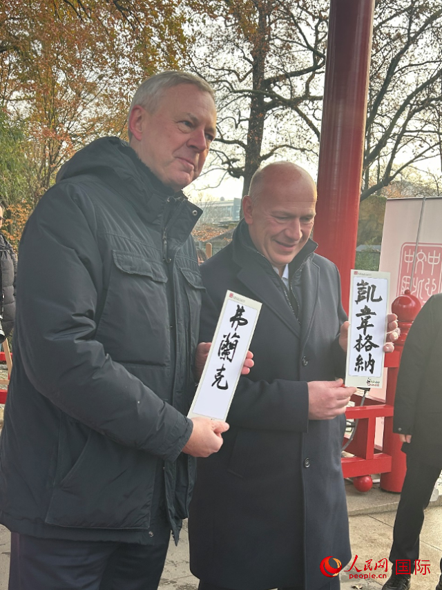 柏林市長韋格納（右）、動物園監(jiān)事會主席布魯克曼（左）手持中國文化中心工作人員現(xiàn)場手書的中文名字。人民網(wǎng)記者 徐馨攝