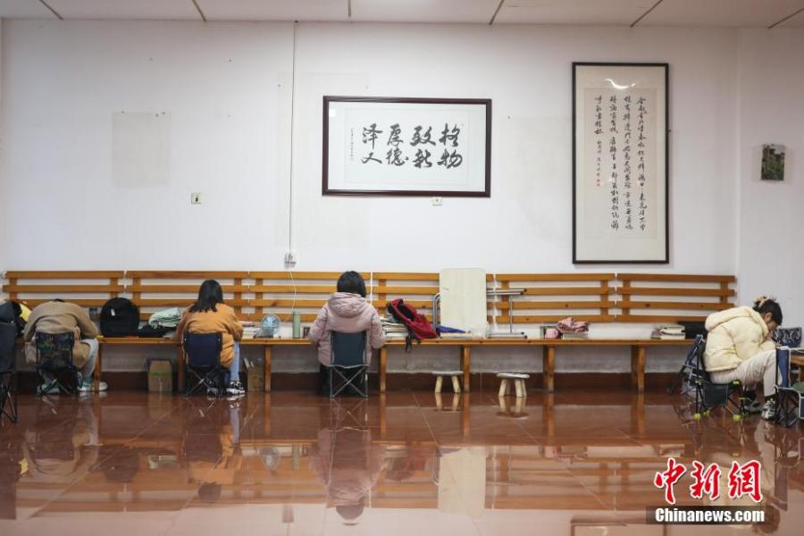 資料圖：幾位考研學(xué)生在南昌大學(xué)教學(xué)樓的公共空間復(fù)習(xí)備考。劉力鑫 攝