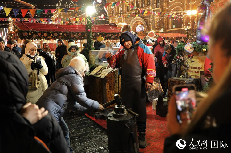 游客在新年集市上體驗制作紀念幣。人民網(wǎng)記者 隋鑫攝