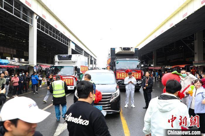 運(yùn)載蔓越莓車(chē)隊(duì)前，不少民眾正在圍觀打卡。 王偉臣 攝