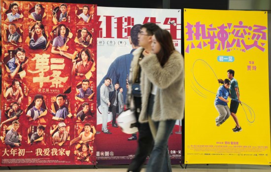 這是2月17日，在沈陽一家影院，觀眾從海報前經(jīng)過。新華社記者李鋼攝