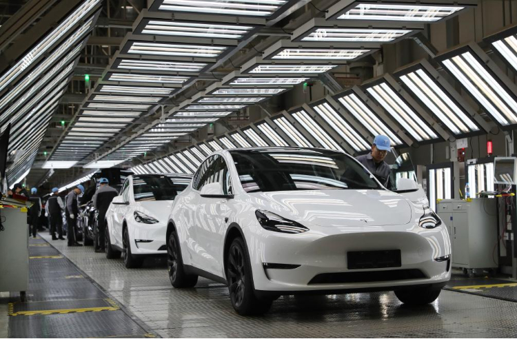 2023年12月22日，在特斯拉上海超級工廠內，工人在對出廠前的車輛進行漆面及門窗檢測。新華社記者 方喆 攝