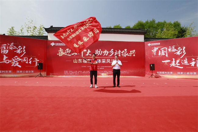 為媒體采風(fēng)團(tuán)授旗。 山東省福彩供圖