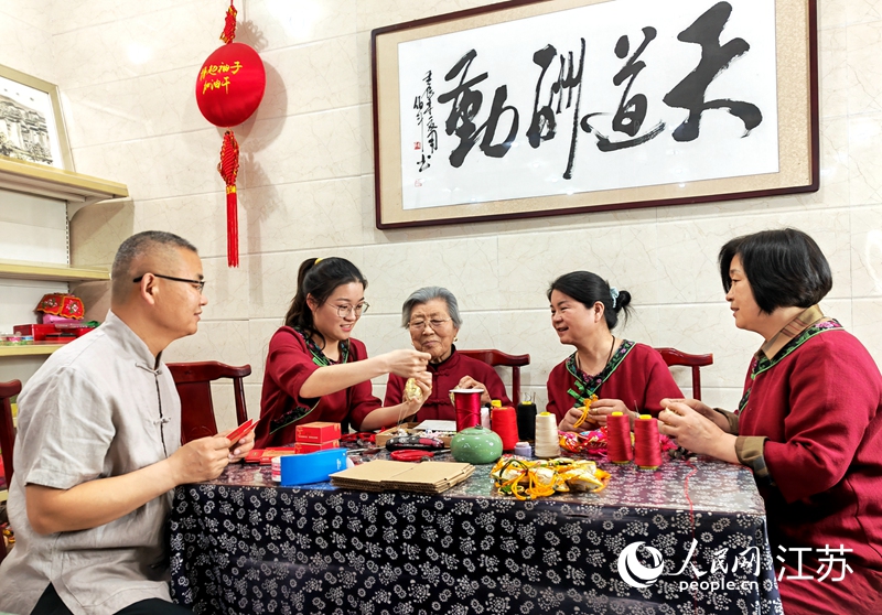 王秀英老人指導(dǎo)孫女制作香包。人民網(wǎng) 閆峰攝