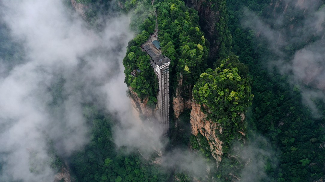 位于張家界武陵源景區(qū)的百龍?zhí)焯蓁偳对谠旗F繚繞的峰林間，雄偉壯觀。吳勇兵攝