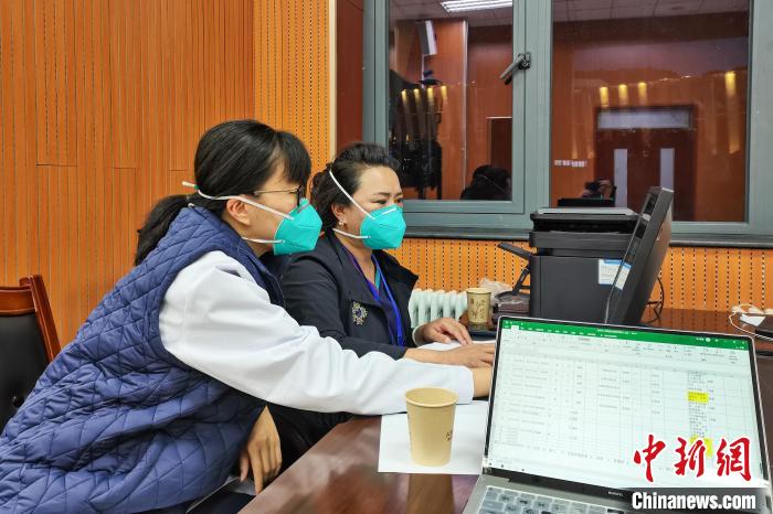 8月9日，楊蘇喬(左)在拉薩方艙醫(yī)院指揮部讀取艙內(nèi)患者胸部CT?！∈茉L者供圖
