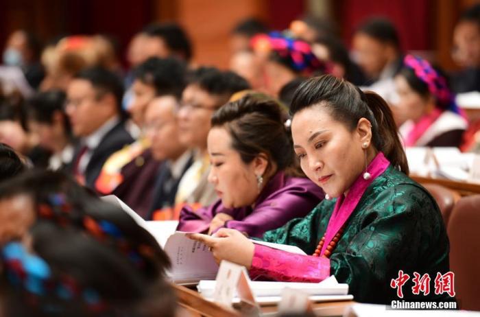 1月5日，次旦卓嘎(右一)在拉薩參加西藏自治區(qū)第十一屆人民代表大會第五次會議第二次全體會議。西藏自治區(qū)人大代表次旦卓嘎來自日喀則市定日縣，定日縣被稱為“洛諧故鄉(xiāng)”，作為西藏民間歌舞，洛諧已被列入中國國家非物質(zhì)文化遺產(chǎn)項目名錄，這是集歌、舞、樂、彈唱于一體的綜合藝術形式。參加完西藏2022年新年音樂會的次旦卓嘎告訴記者，每年參加的基層演出可達80場，“我希望用最純粹的方式，把最好的聲音帶到西藏乃至中國的各個角落?！?<a target='_blank' href='/'><p  align=