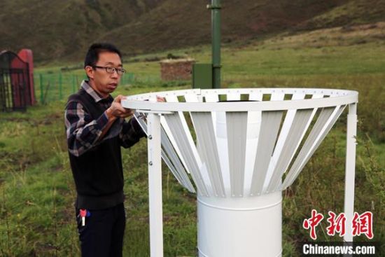 圖為班瑪縣氣象局工作人員在維護藏雪茶基地氣候站。青海省氣象局供圖