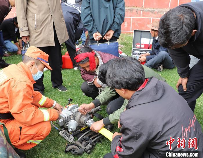 圖為森林消防員為護(hù)林員講解滅火裝備的使用方法。　昌都市森林消防支隊(duì) 供圖