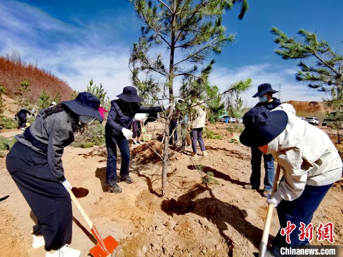 圖為西寧市城東區(qū)干部職工參加義務(wù)植樹?！?zhí)砀?攝