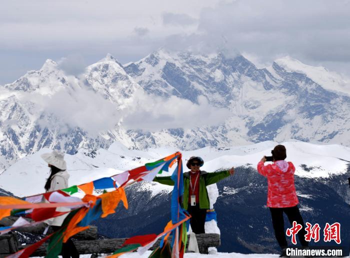 圖為5月14日，西藏林芝色季拉山觀景臺，游客與南迦巴瓦峰合影。　李林 攝