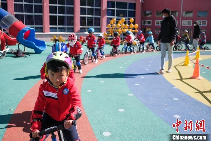 圖為拉薩市實驗幼兒園孩子們在教練的指導(dǎo)下練習(xí)滑步車?！『闻罾?攝