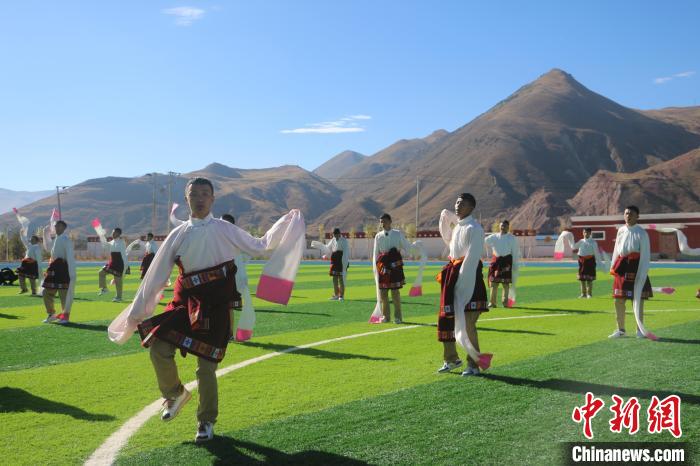 圖為青海師范大學(xué)附屬玉樹實驗學(xué)校學(xué)生在綠茵場跳起囊謙古舞—卓根瑪?！〕逃?攝