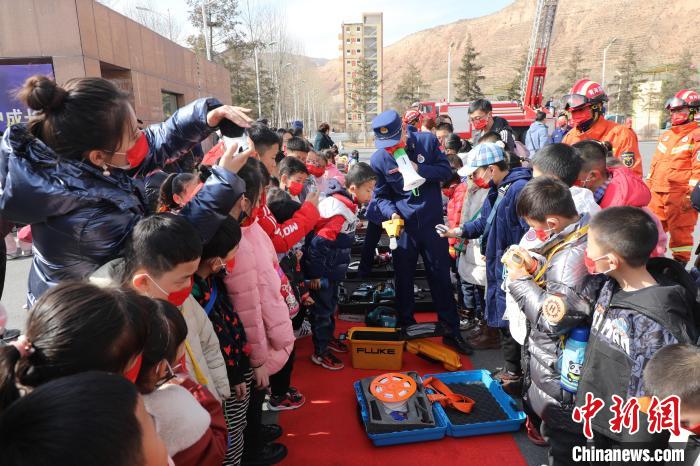圖為小朋友們聽消防員講解消防器材。　楊龍建 攝