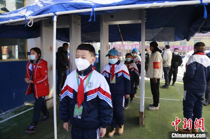 圖為學(xué)生測量體溫后進入校園?！●R銘言 攝