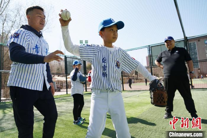 圖為教練指導(dǎo)小棒球手?jǐn)S球技術(shù)?！●R銘言 攝