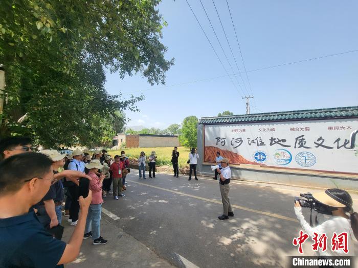 圖為中國地質(zhì)大學(xué)(北京)教授張緒教介紹村落情況?！『衍?攝