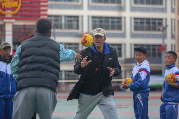 在高原上教孩子們打手球，“慢慢兒來，甭著急！”