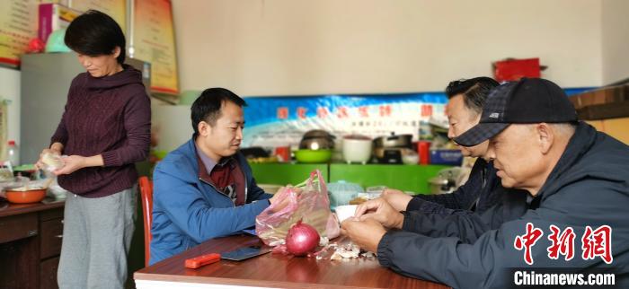 圖為扶貧路上“臨時一家人”準備午餐。　魏建軍 攝