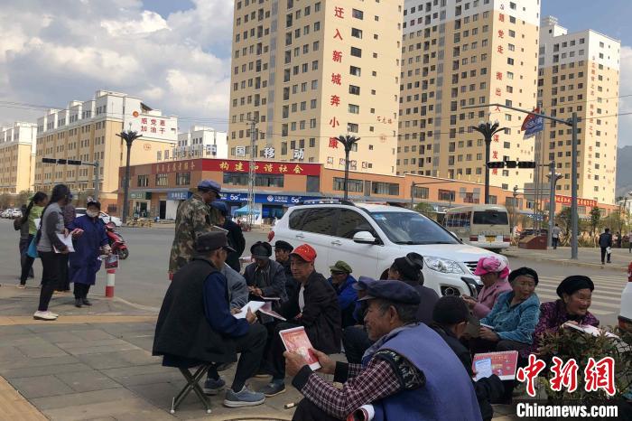 圖為會(huì)澤縣城易地扶貧搬遷安置點(diǎn)內(nèi)，老人們聚在廣場(chǎng)上聊天，身后是他們的新家?！】姵?攝