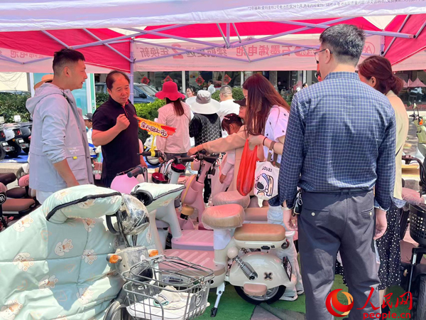 某電動自行車品牌工作人員向消費者介紹以舊換新相關(guān)情況。人民網(wǎng)記者 杜燕飛攝