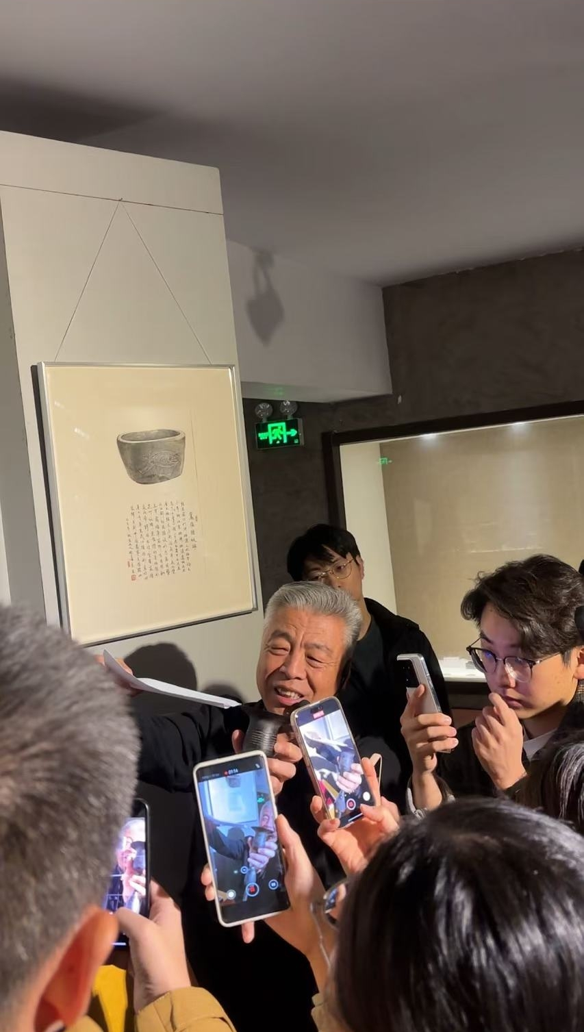 黑陶邢文化博物館館長邢葆東展示兩張相疊的A4紙，向記者解釋此為杯口的厚度。