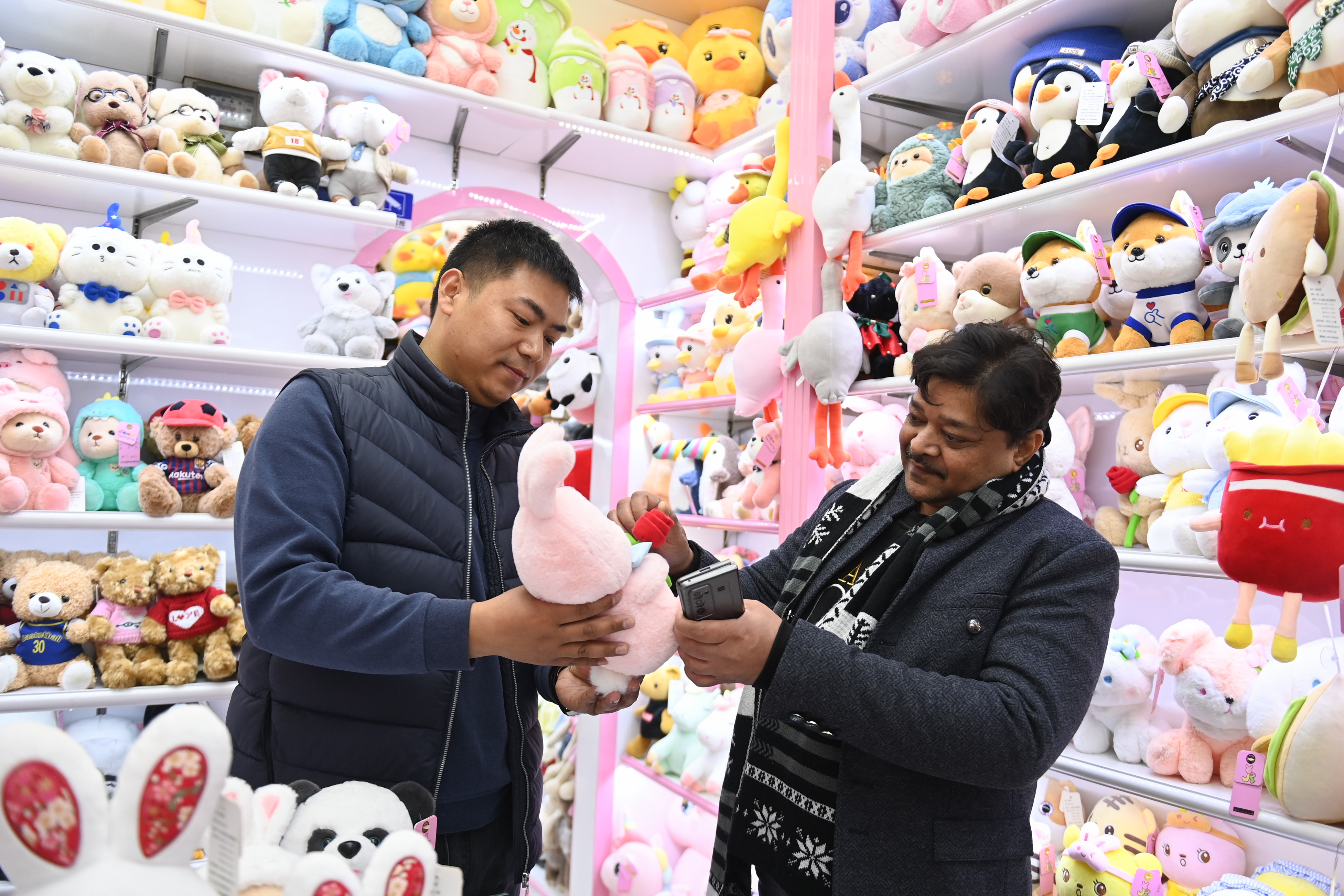 2023年2月2日，來(lái)自印度的客商（右）在義烏國(guó)際商貿(mào)城的一家玩具店鋪內(nèi)選購(gòu)。