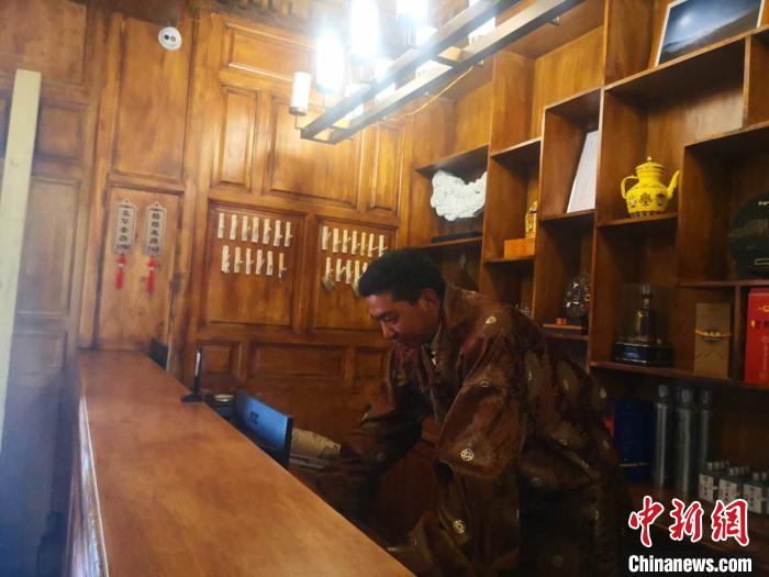 圖為桑杰才讓用電腦處理財(cái)務(wù)?！∈缝o靜 攝