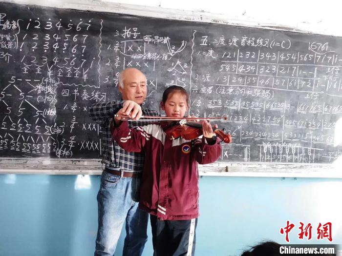圖為趙興洲教學生拉小提琴。受訪者提供
