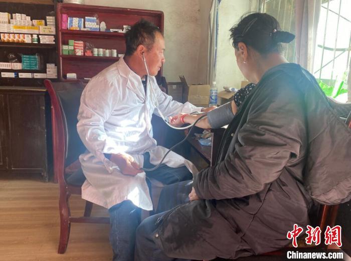 索木滾(左)為村民看病。　壤塘縣委宣傳部供圖
