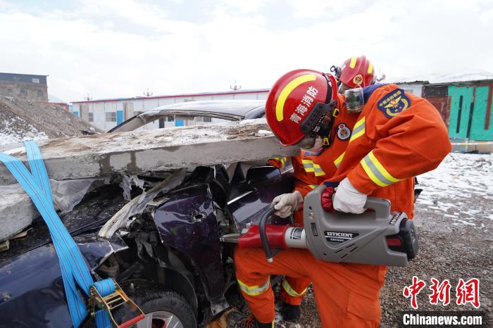 圖為地震實戰(zhàn)拉動現(xiàn)場，參演人員進行車輛破拆?！∮駱湎拦﹫D