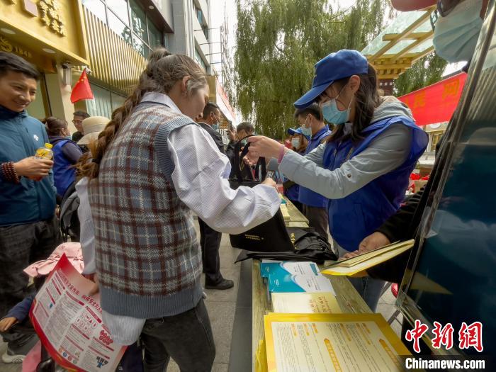 圖為志愿者為市民發(fā)放網(wǎng)絡(luò)安全宣傳手冊(cè)?！≈x牧 攝